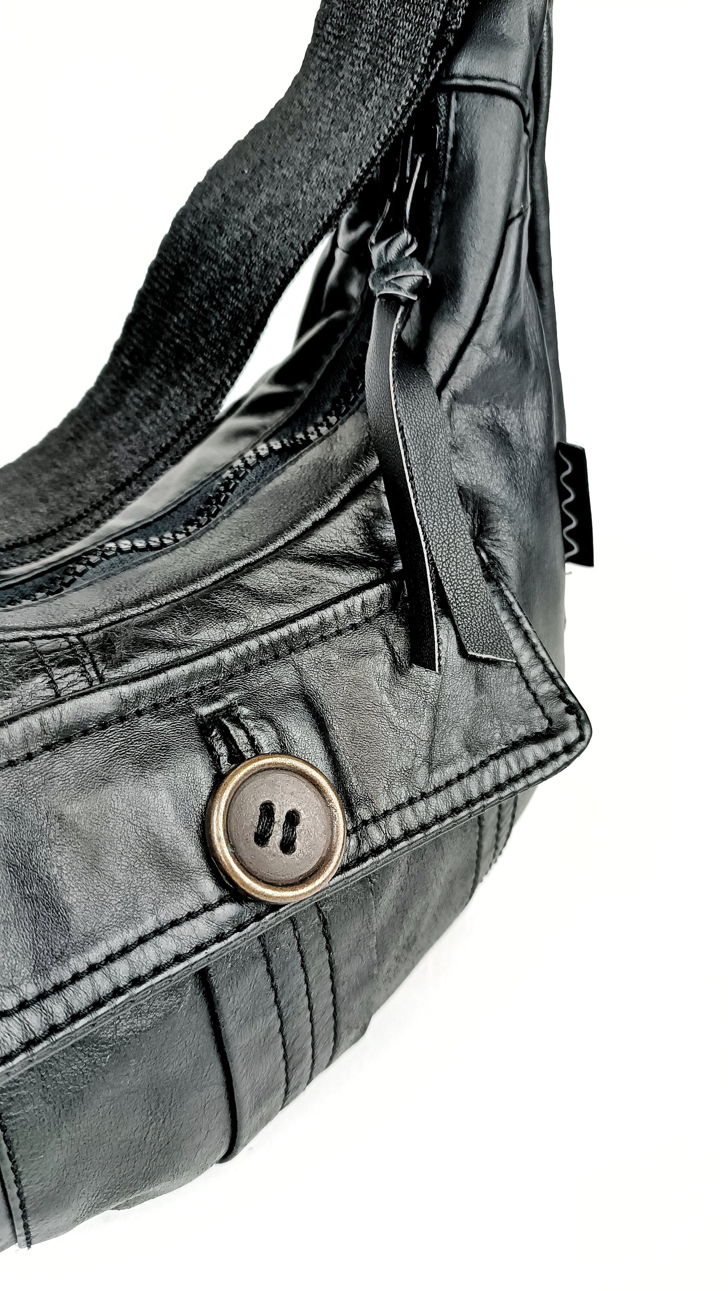 Detailansicht der schwarzen Baguette Bag aus Vintage Glattleder Außentasche mit Knopf