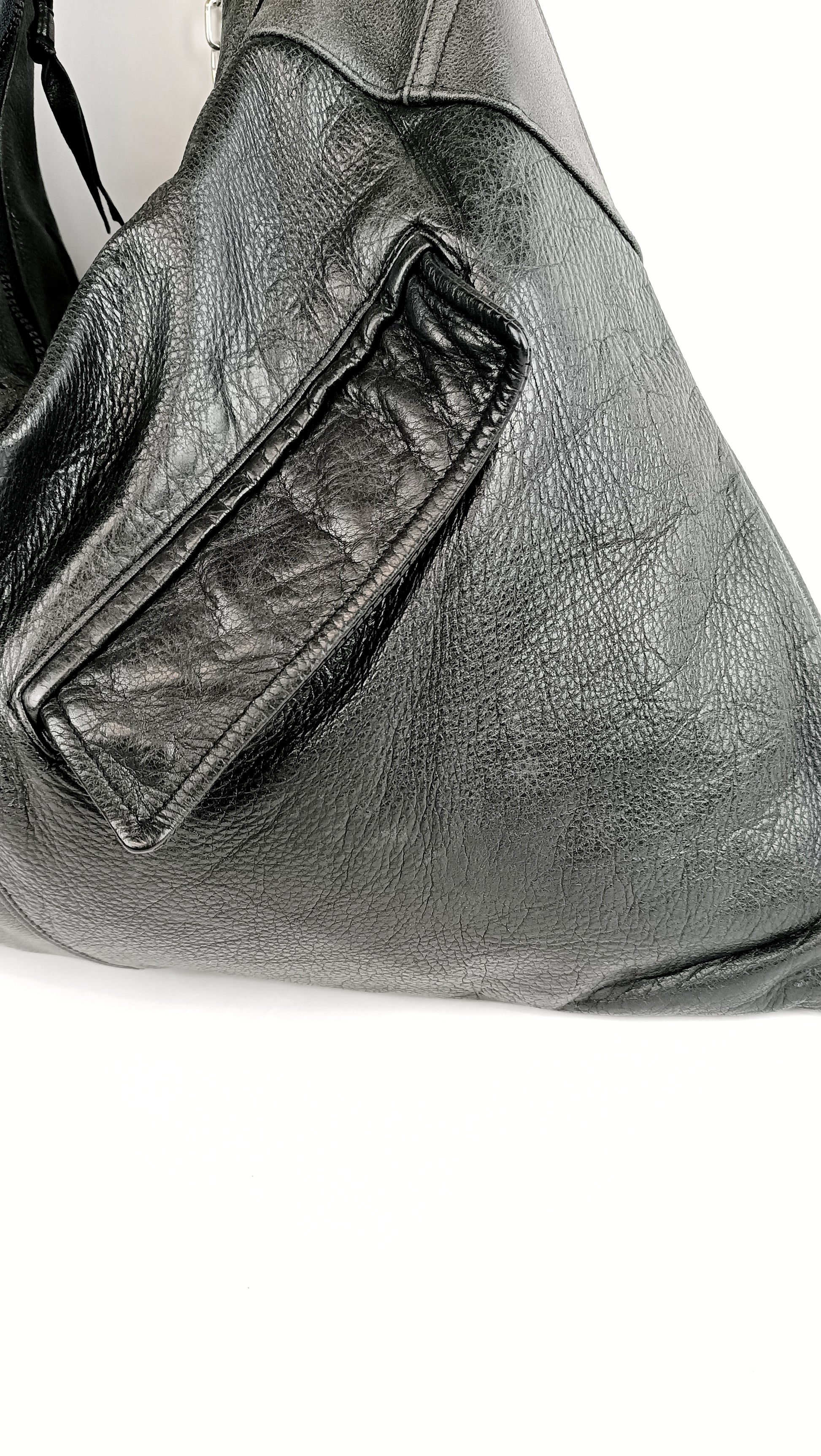 Detailansicht der schwarzen Triangle Bag aus Leder mit Pattentaschen