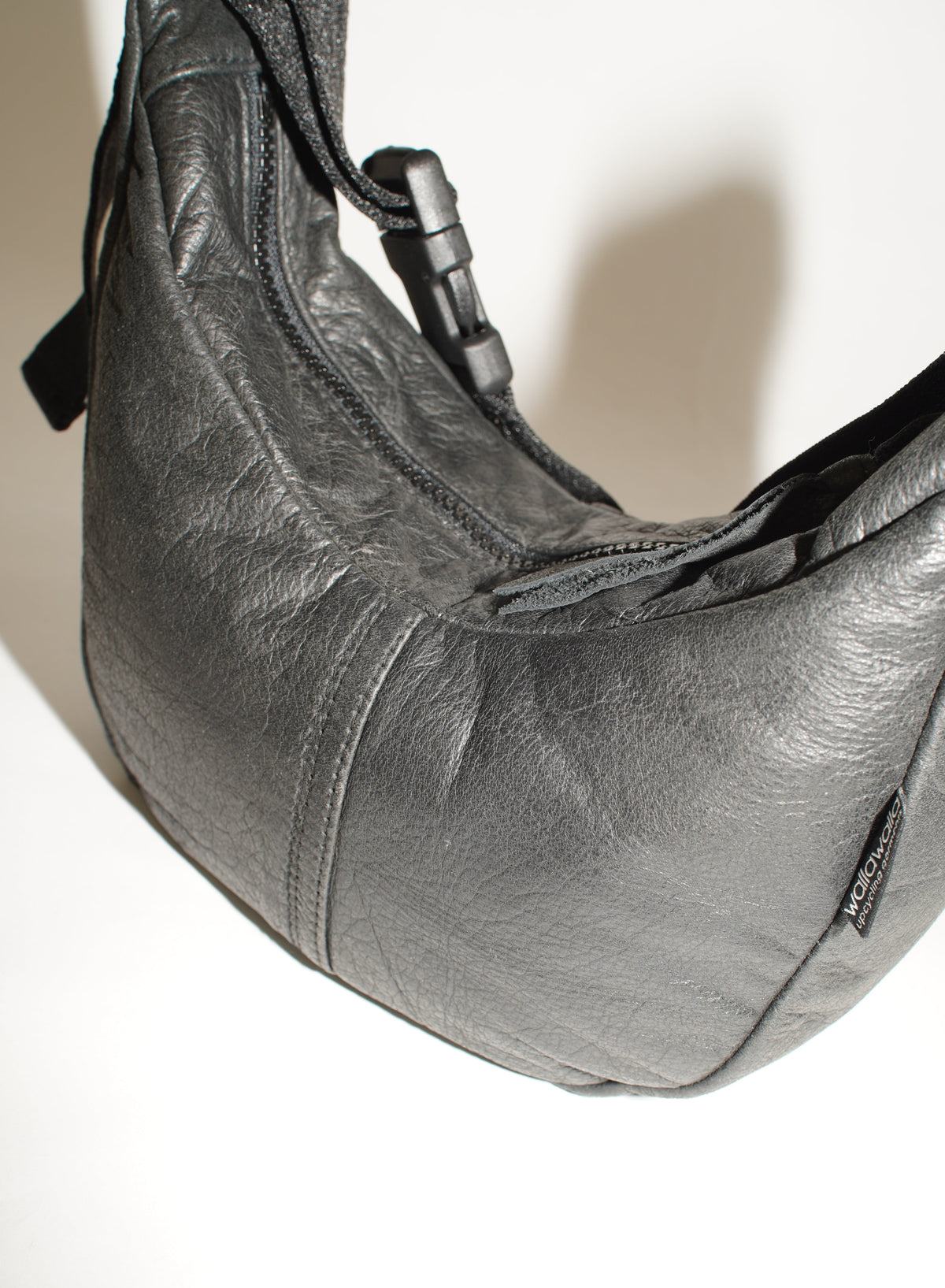 Detailansicht der schwarzen Crossbody Bag mit natürlicher Rindslederstruktur