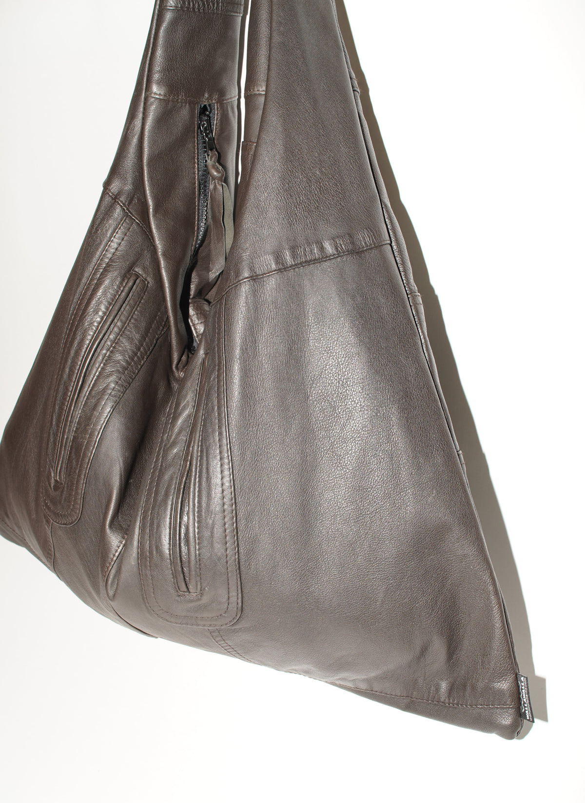 Seitenansicht der braunen Triangle Bag L mit fein strukturierter Lederoberfläche