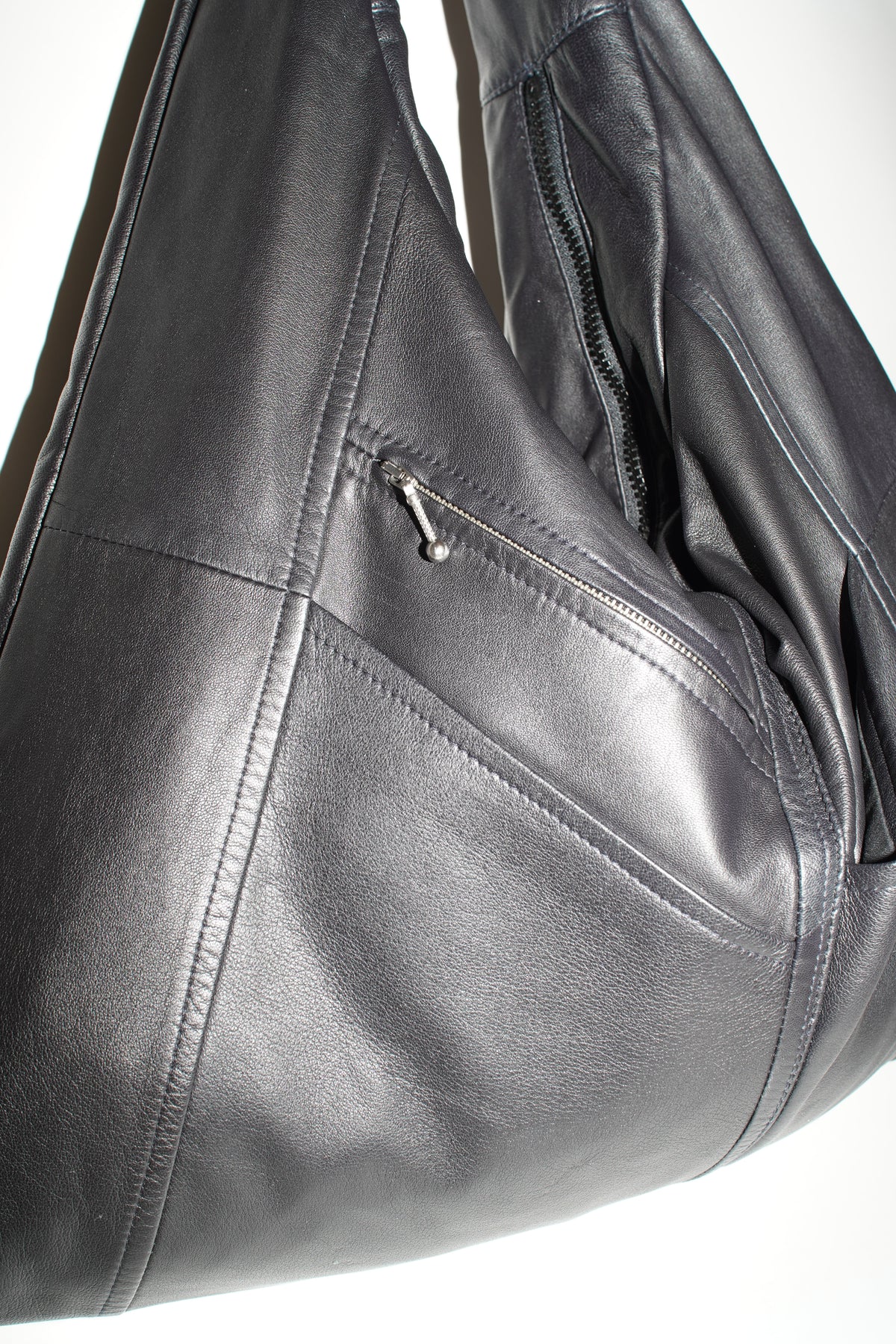 Nahaufnahme der leicht glänzenden schwarzen Lederoberfläche der Triangle Bag L