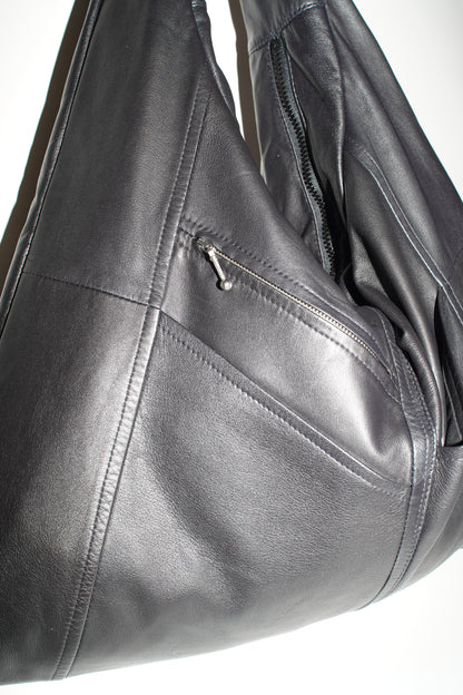 Nahaufnahme der leicht glänzenden schwarzen Lederoberfläche der Triangle Bag L